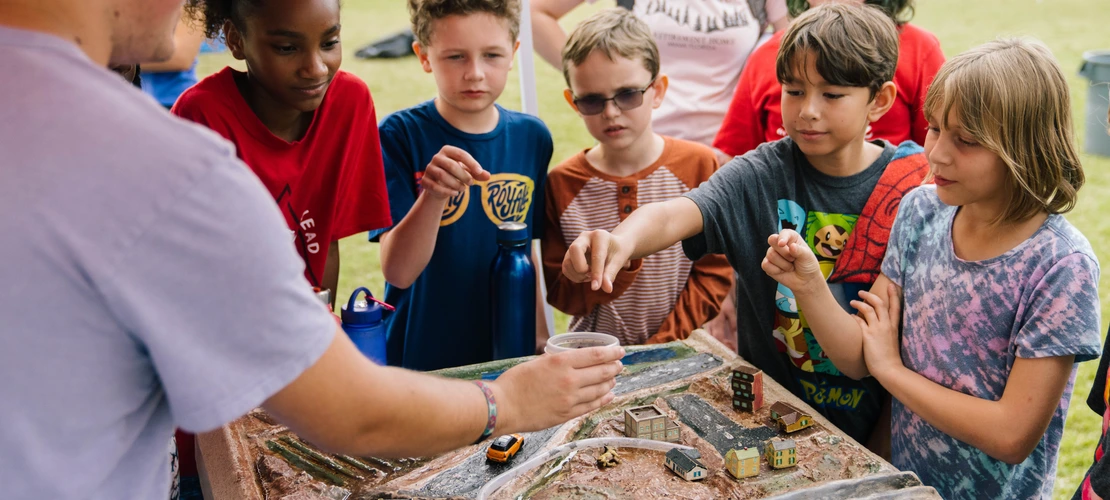 Students playing with a 3-d model of a watershed