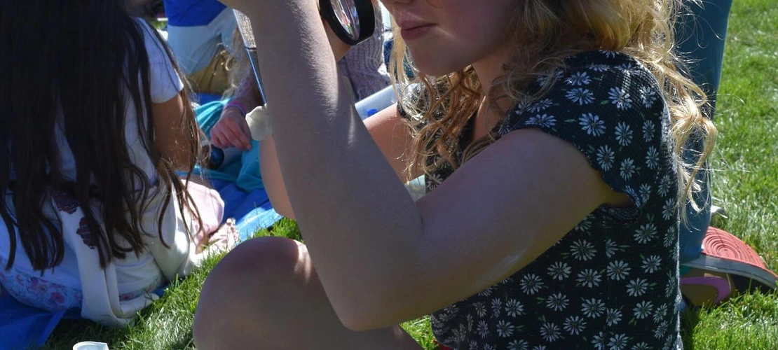 student inspecting earth materials in a tube