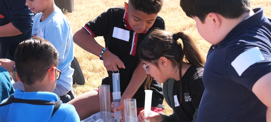 Students pumping groundwater out of an aquifer model at a water festival