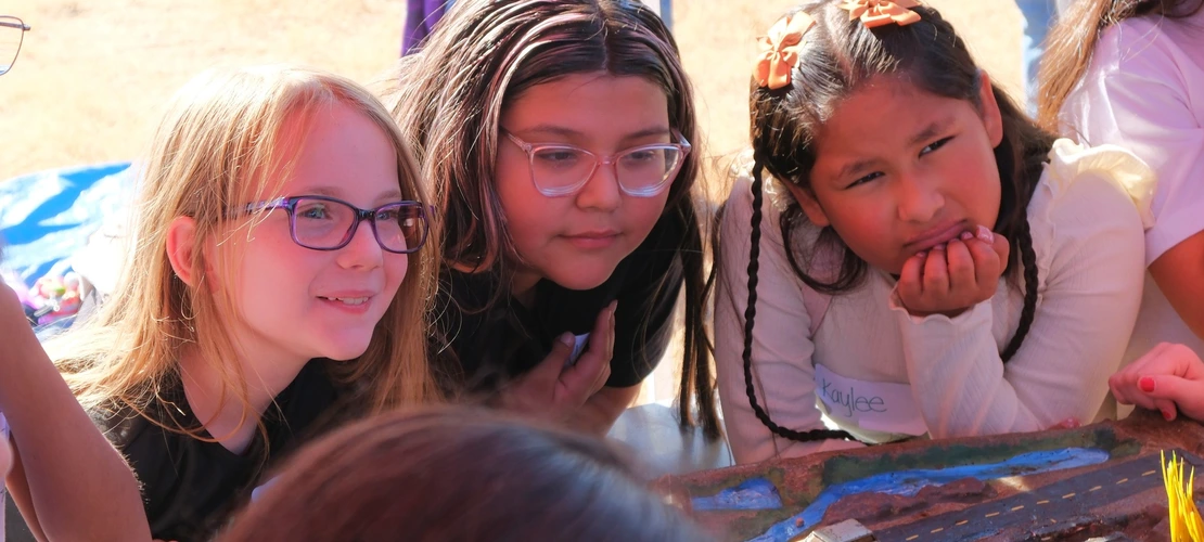 Group of girls posing for a photo at a water festival watershed model