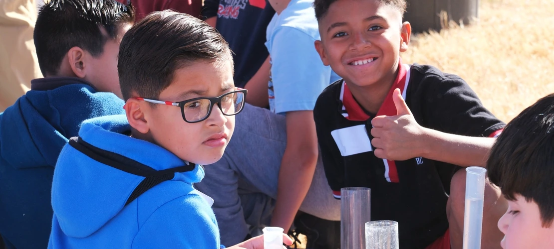 Student with a thumb up at a water festival activity