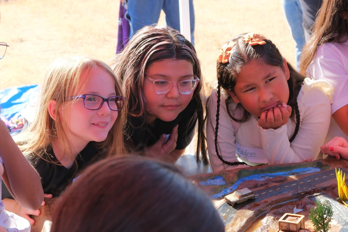Group of girls posing for a photo at a water festival watershed model
